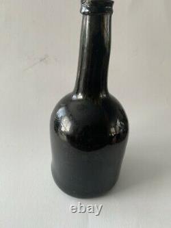 An antique black glass bottle from the end of the 18th. Century, onion bottle